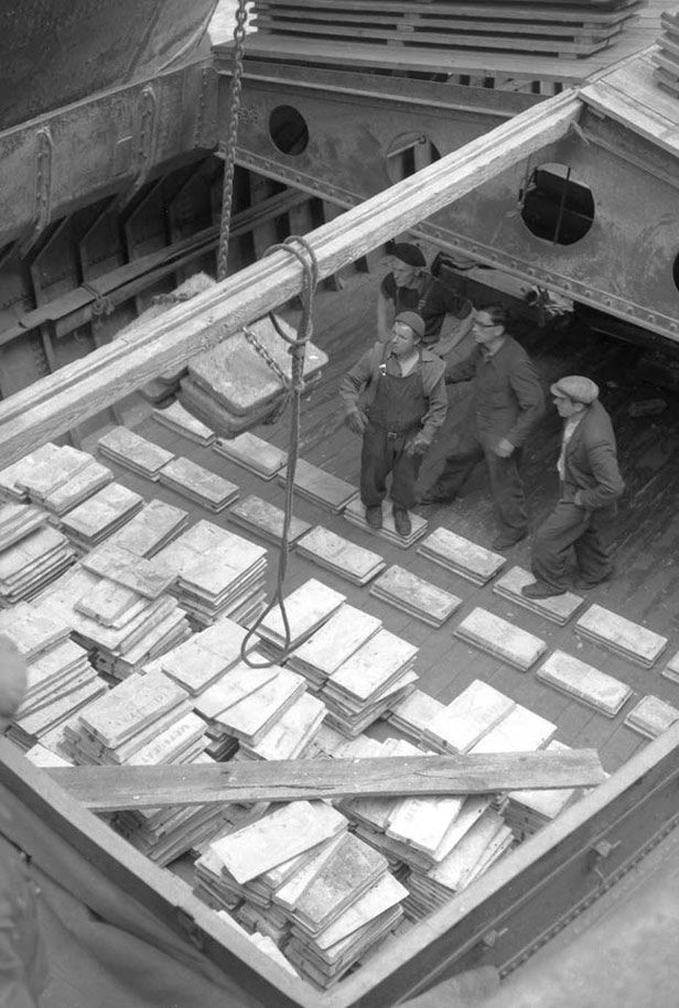 Dockworkers on hold of ship with metal ingots