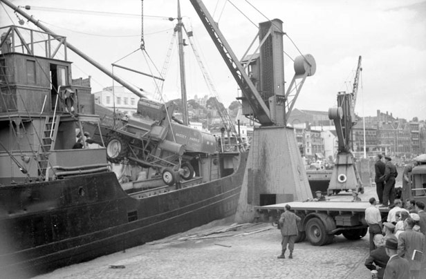 Combine havester lowered onto flatbed